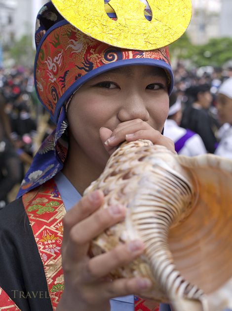 Girl with shell horn at Tug of War Festival, Okinawa