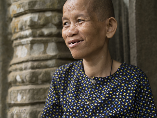 Cambodian woman at Ta Prohm temple ruin in the forest. Siem Reap, Cambodia