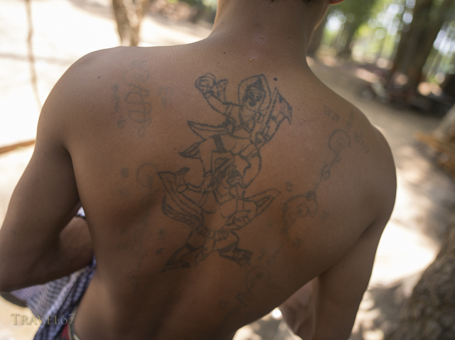 Monk with tattoos at Lolei Temple ( Roluos Group ) , Siem Reap, Cambodia