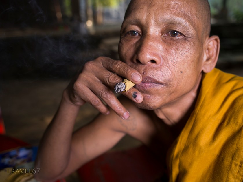 Cambodian Buddhist monk smoking a handrolled cigar made with sankai leaf.