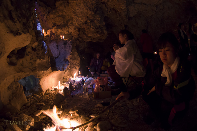 Yuta (priestess) Ayako Toguchi conducts prayers at sea cave called Sururu Gama on the coast of Kouri Island, Okinawa, Japan