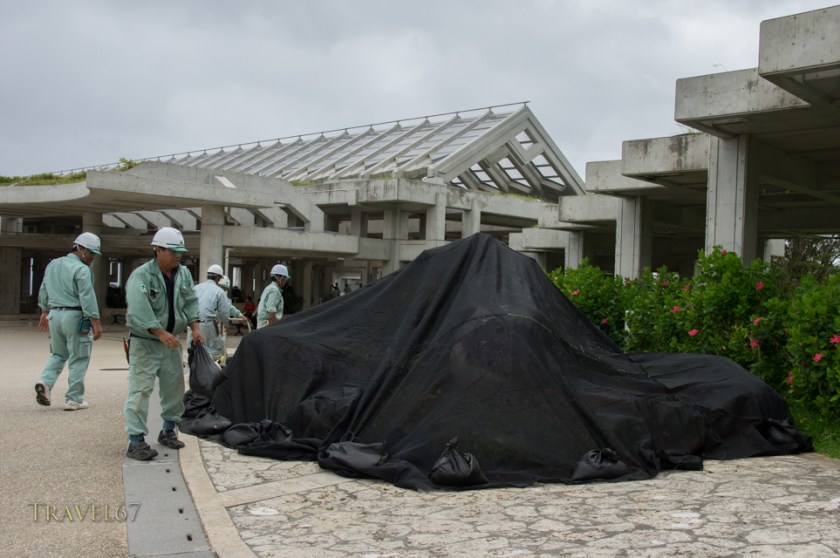 Staff at the Churaumi Aquarium protect flower arrangements. Typhoon Chan-hom brings strong wind and rain to the islands of Okinawa, Japan 9 July 2015